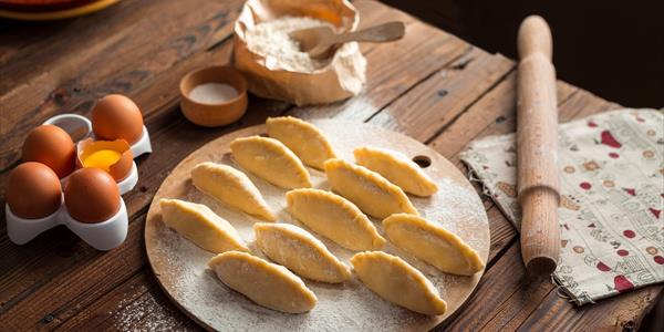 Un piatto di pasta fresca, appena preparata, pronta per essere cotta, con ingredienti freschi come uova e farina